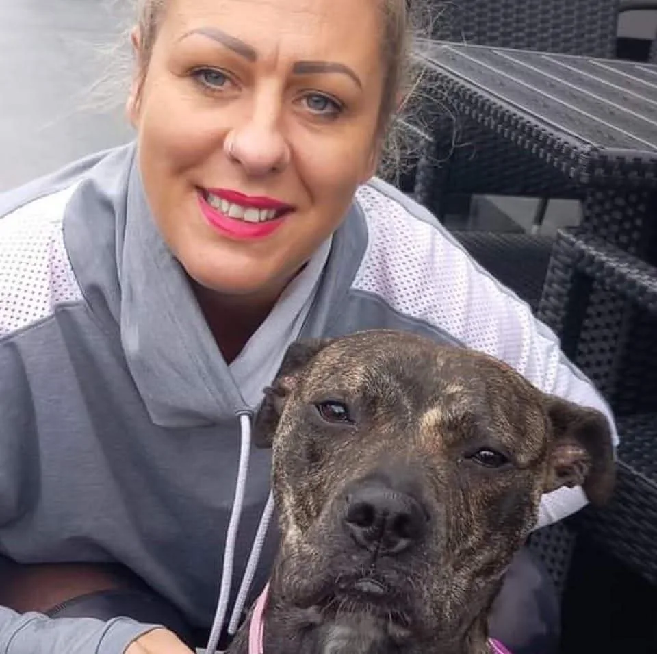 Gemma Buckton smiling with a brindle dog